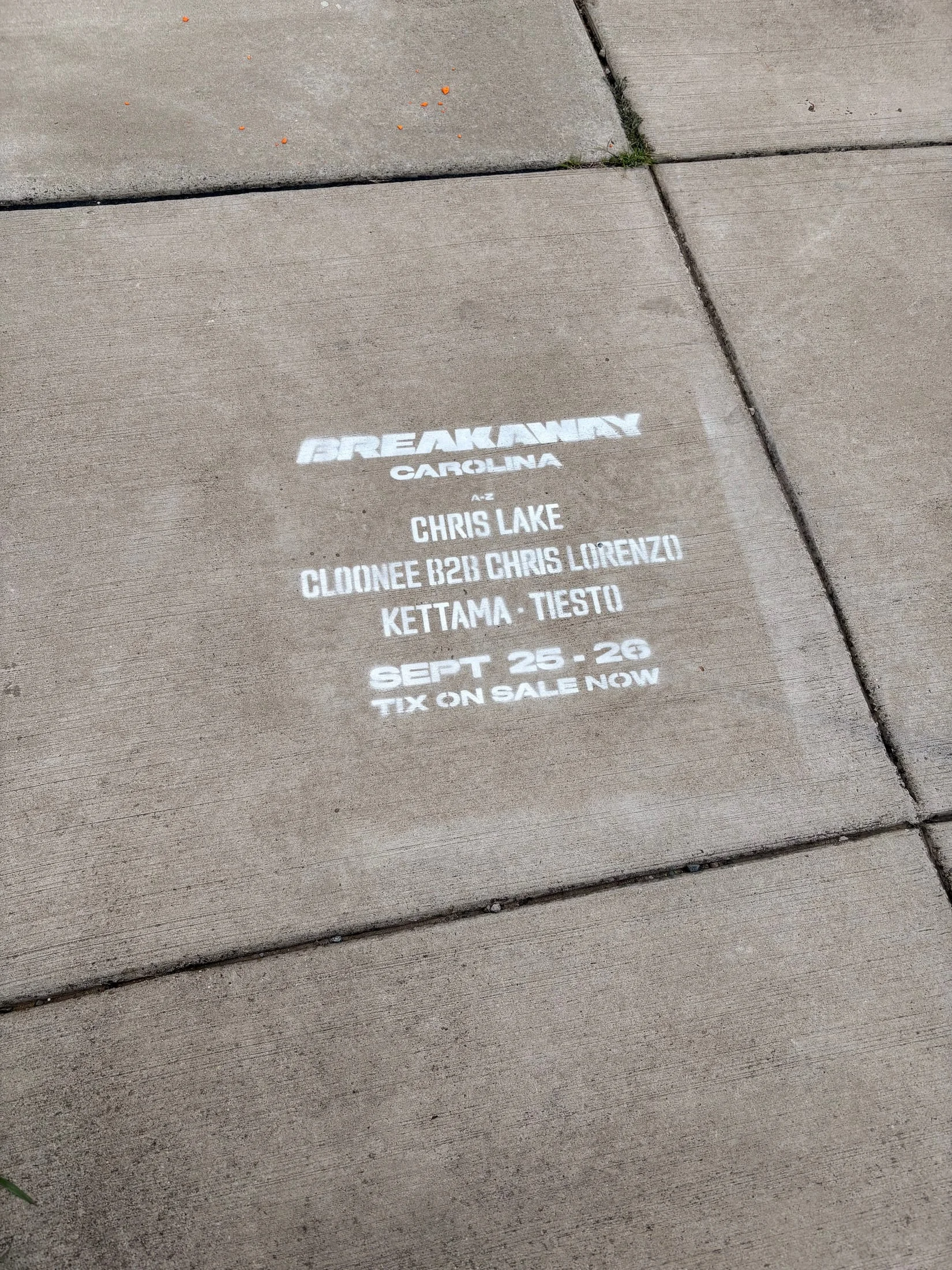 Chalk sidewalk stencil with the Breakaway Carolina festival lineup and ticket dates, Uptown Charlotte