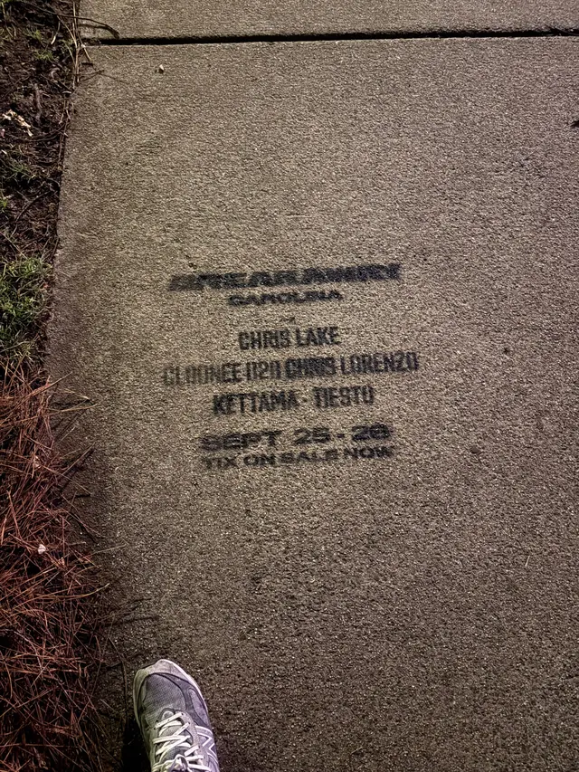 Sidewalk stencil for Breakaway Carolina with a pedestrian's shoe for scale, Cleveland Ave, South End Charlotte