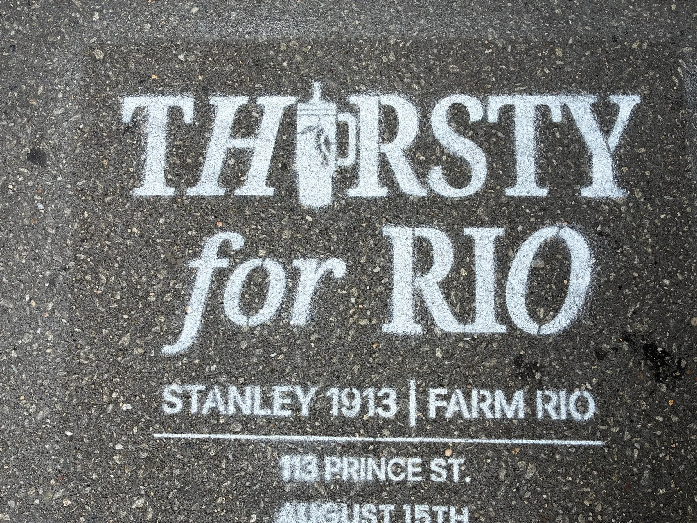 Bold Thirsty for Rio stencil across a dark speckled SoHo paver.