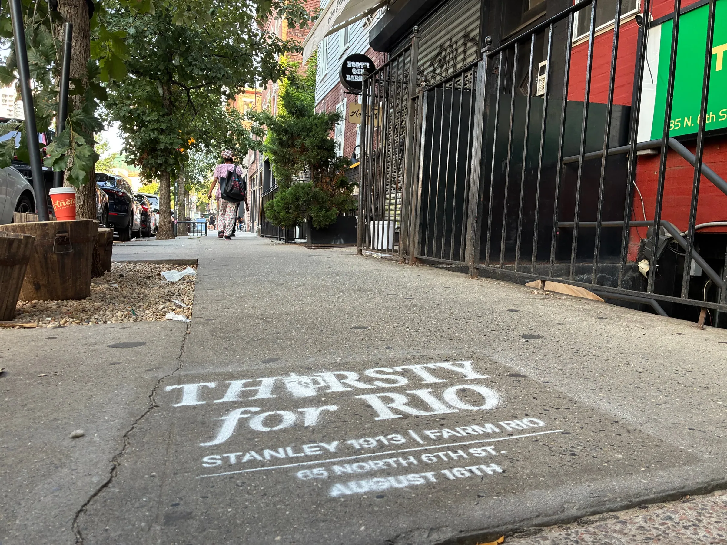 North 6th St sidewalk corridor with the stencil placed mid-walkway between planters, Williamsburg.