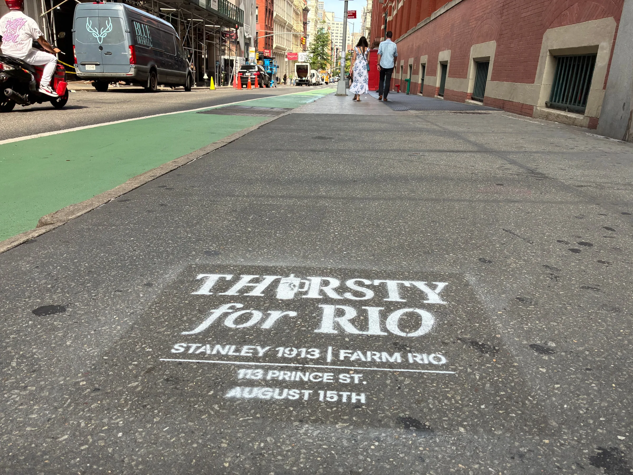 Stencil beside the green Prince St bike lane with the SoHo crosswalk beyond.