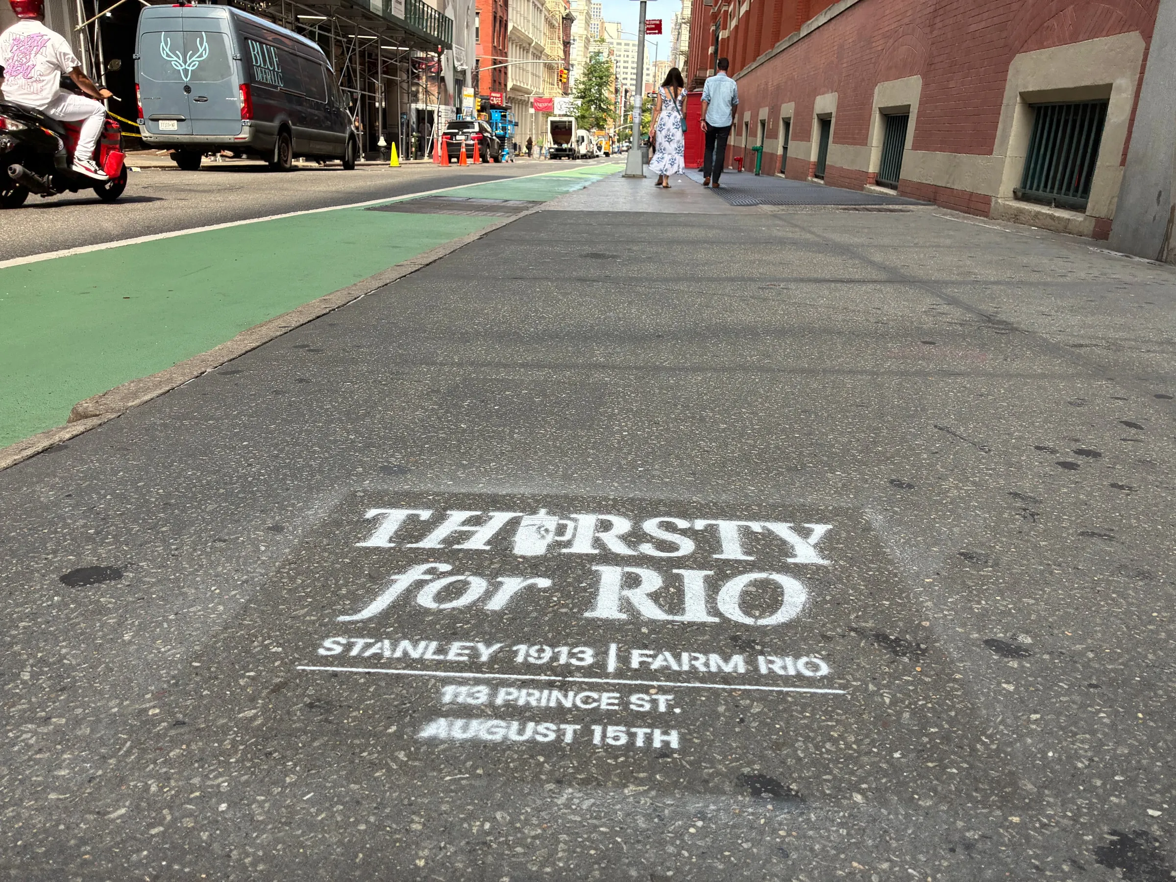 Stencil beside the green Prince St bike lane with the SoHo crosswalk beyond.