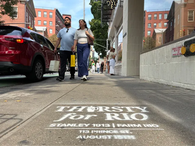 Two shoppers walking past the Thirsty for Rio stencil on the Prince St approach in SoHo.