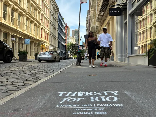 Pedestrians passing the stencil on a cobbled SoHo block with the Givenchy storefront beyond.