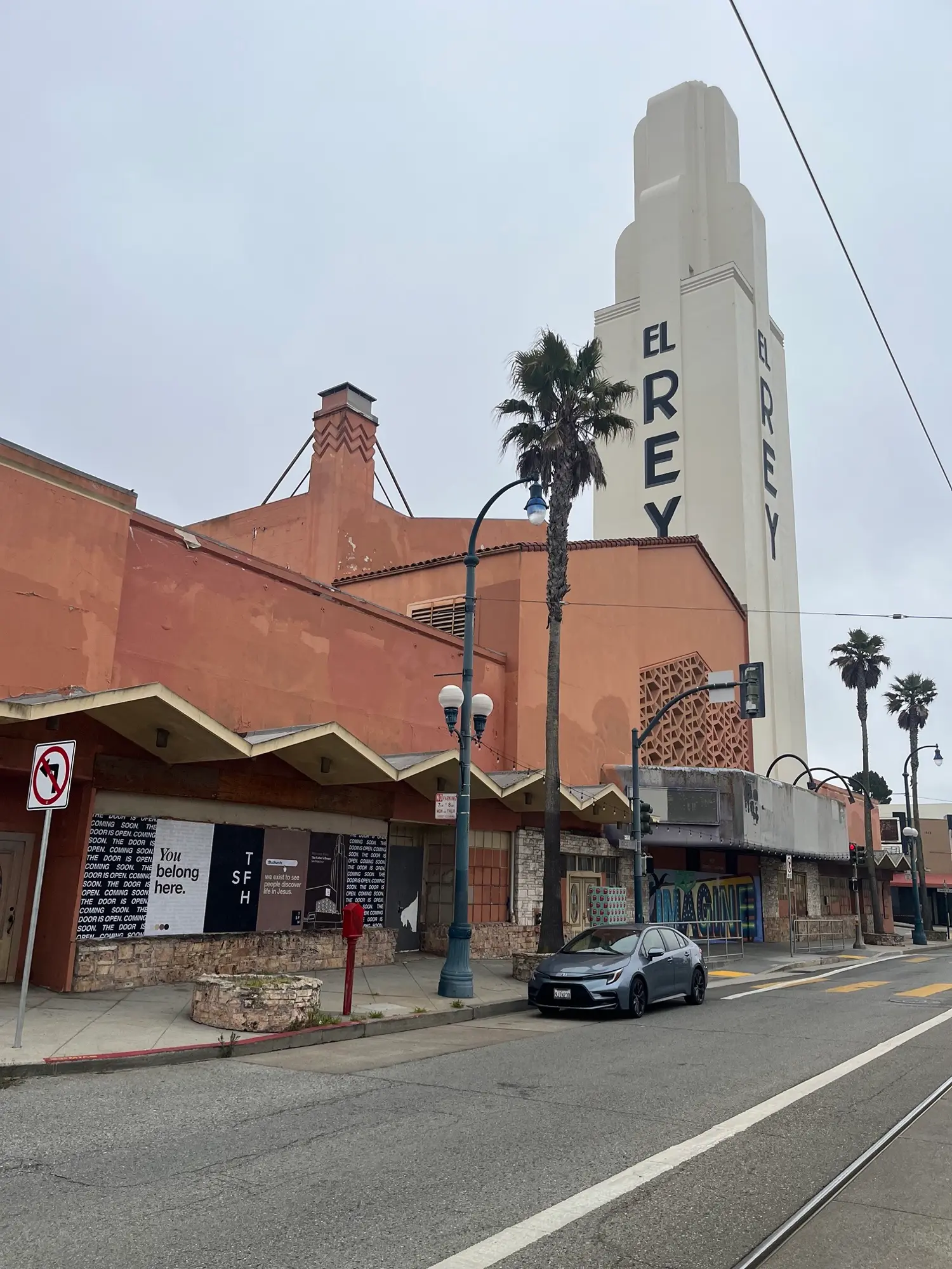 Jumbo custom-branded posters for The Father's House SF covering a street-level wall on Ocean Avenue in San Francisco, CA by Beyond Street Media
