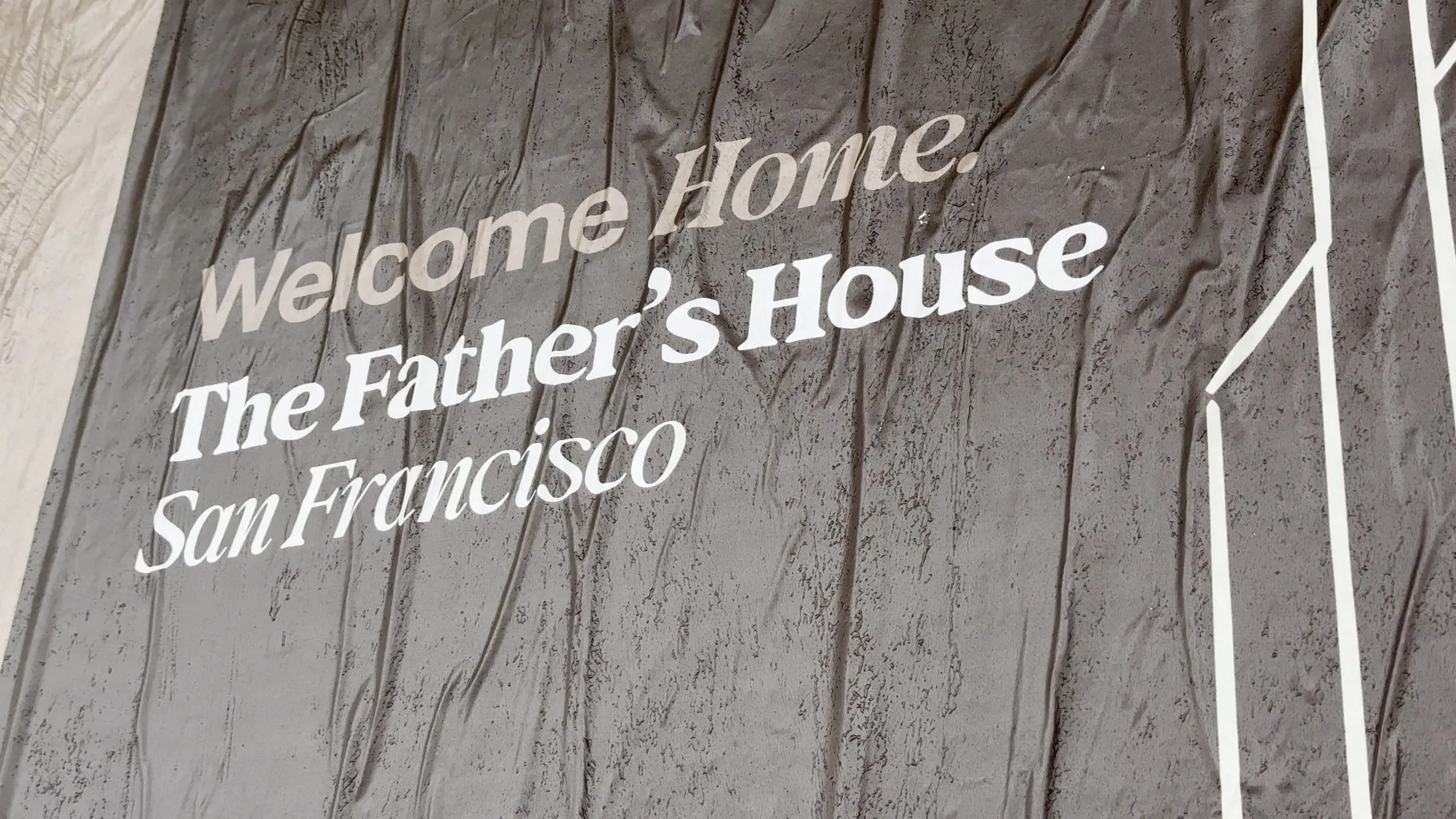 Jumbo custom-branded posters for The Father's House SF covering a street-level wall on Ocean Avenue in San Francisco, CA by Beyond Street Media