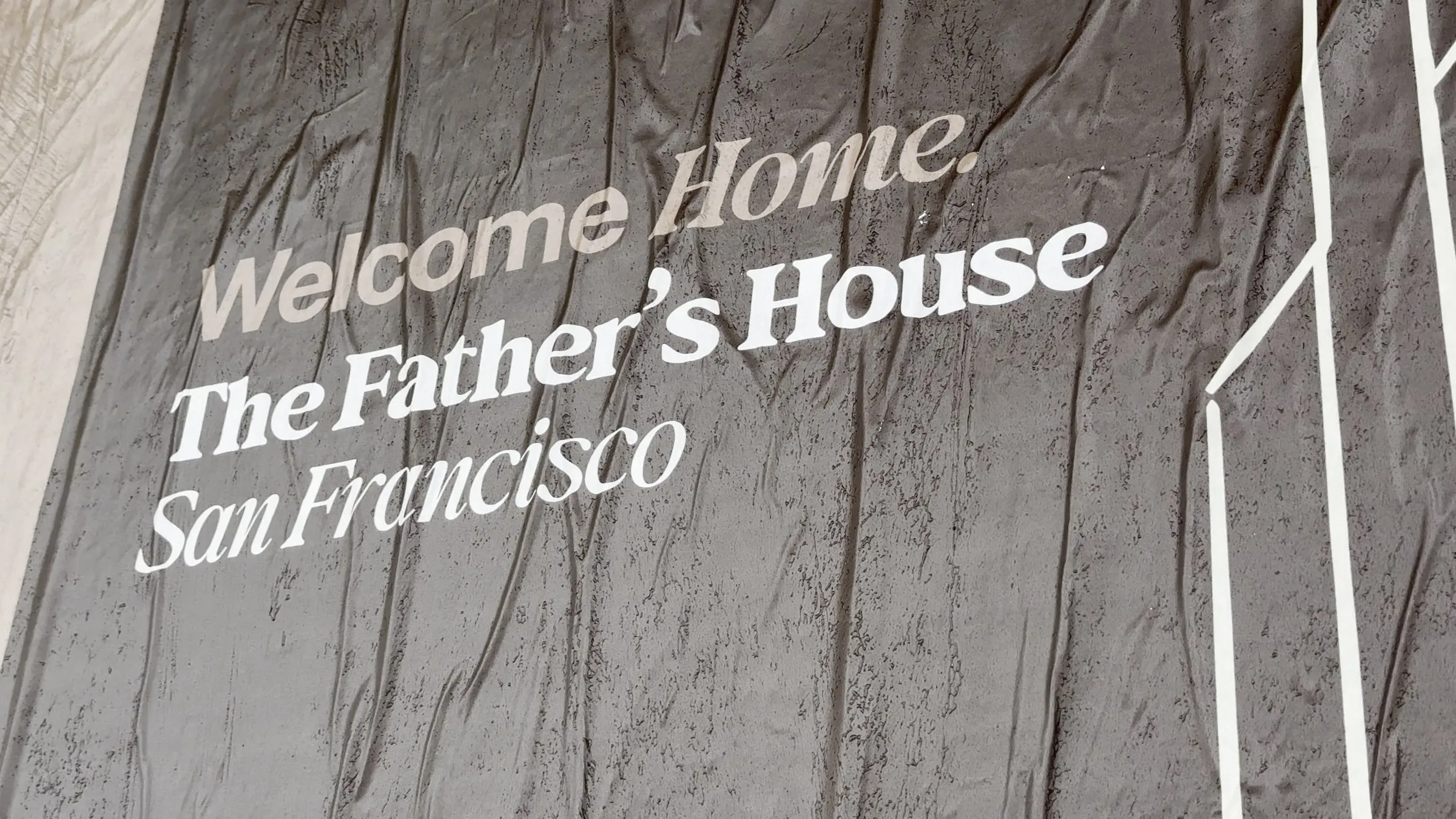 Jumbo custom-branded posters for The Father's House SF covering a street-level wall on Ocean Avenue in San Francisco, CA by Beyond Street Media