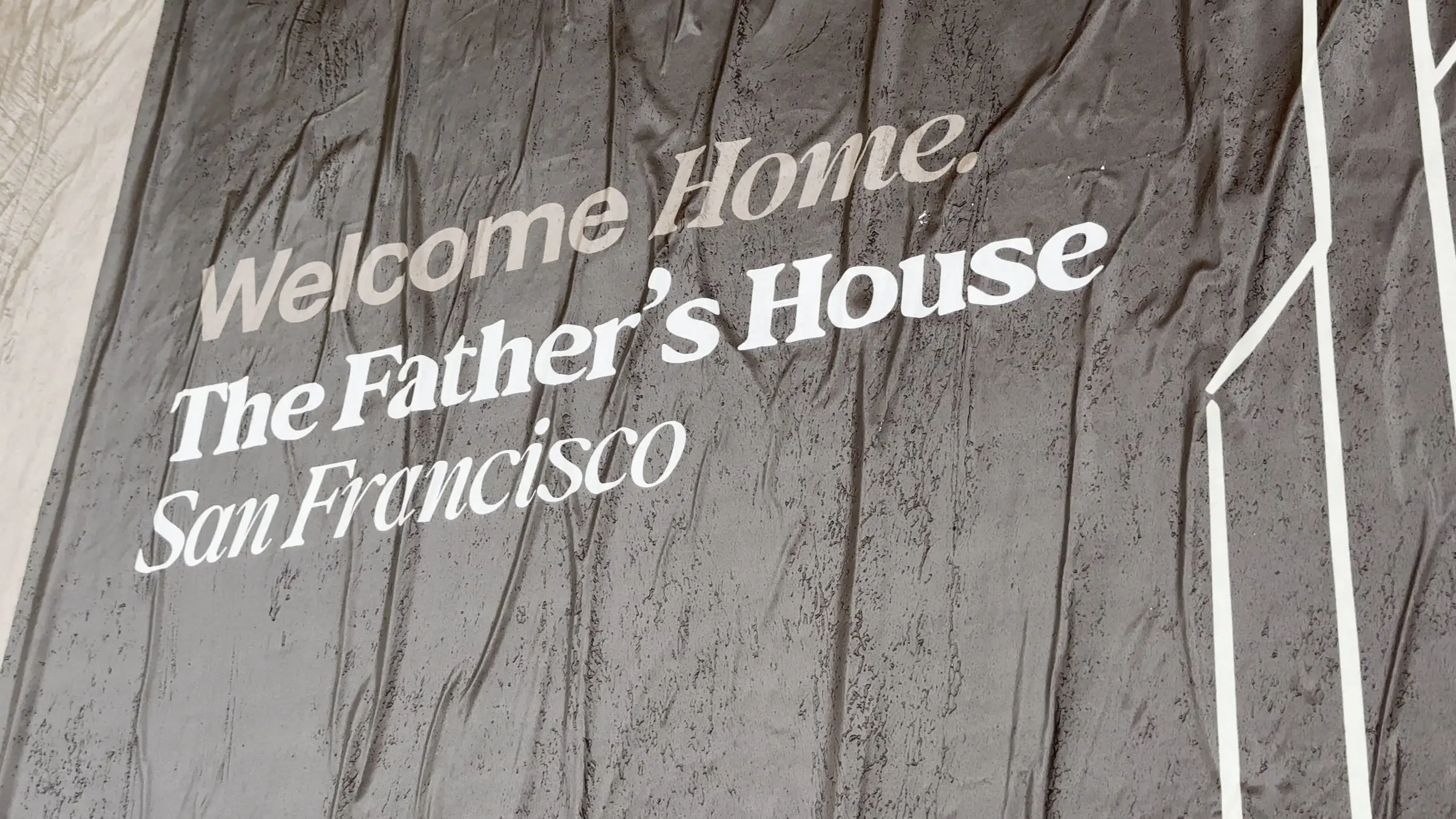 Jumbo custom-branded posters for The Father's House SF covering a street-level wall on Ocean Avenue in San Francisco, CA by Beyond Street Media