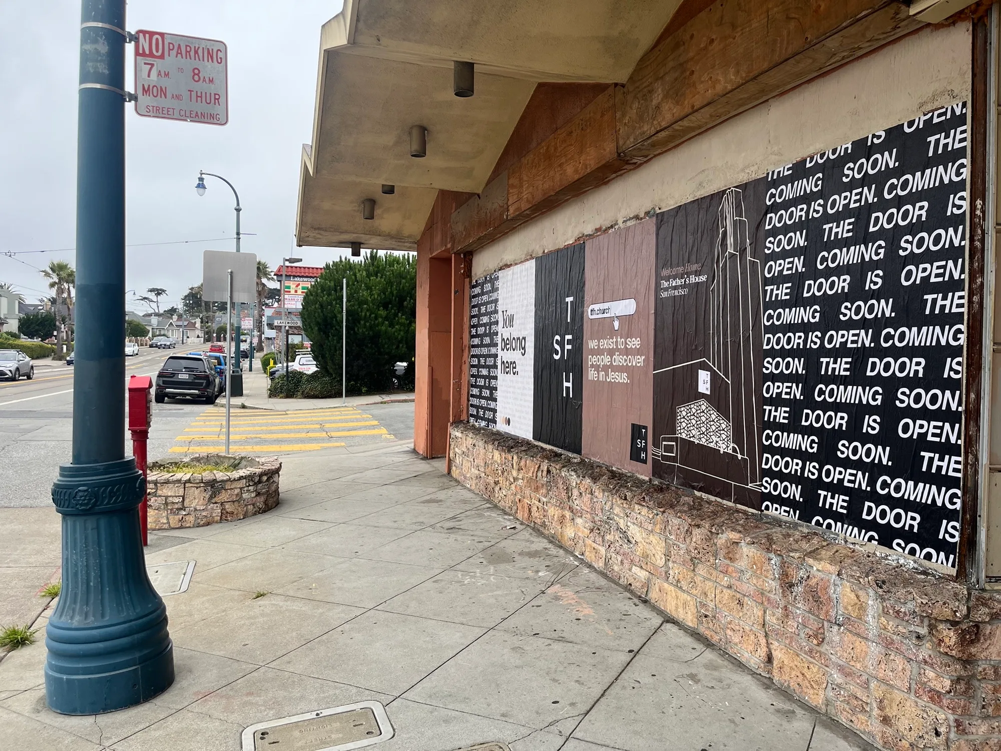 Jumbo custom-branded posters for The Father's House SF covering a street-level wall on Ocean Avenue in San Francisco, CA by Beyond Street Media