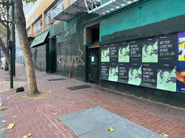 Huckberry wheatpaste posters on a teal and black wall on Market Street between Gough and Octavia, a recessed doorway and trees along the sidewalk