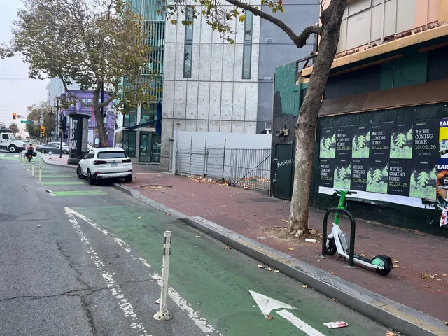 Huckberry wheatpaste posters on a dark wall on Market Street between Gough and Octavia, seen across the protected bike lane