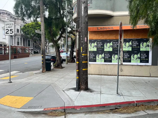 Huckberry wheatpaste posters on a boarded storefront under an orange Laguna awning at Hayes and Laguna, Hayes Valley