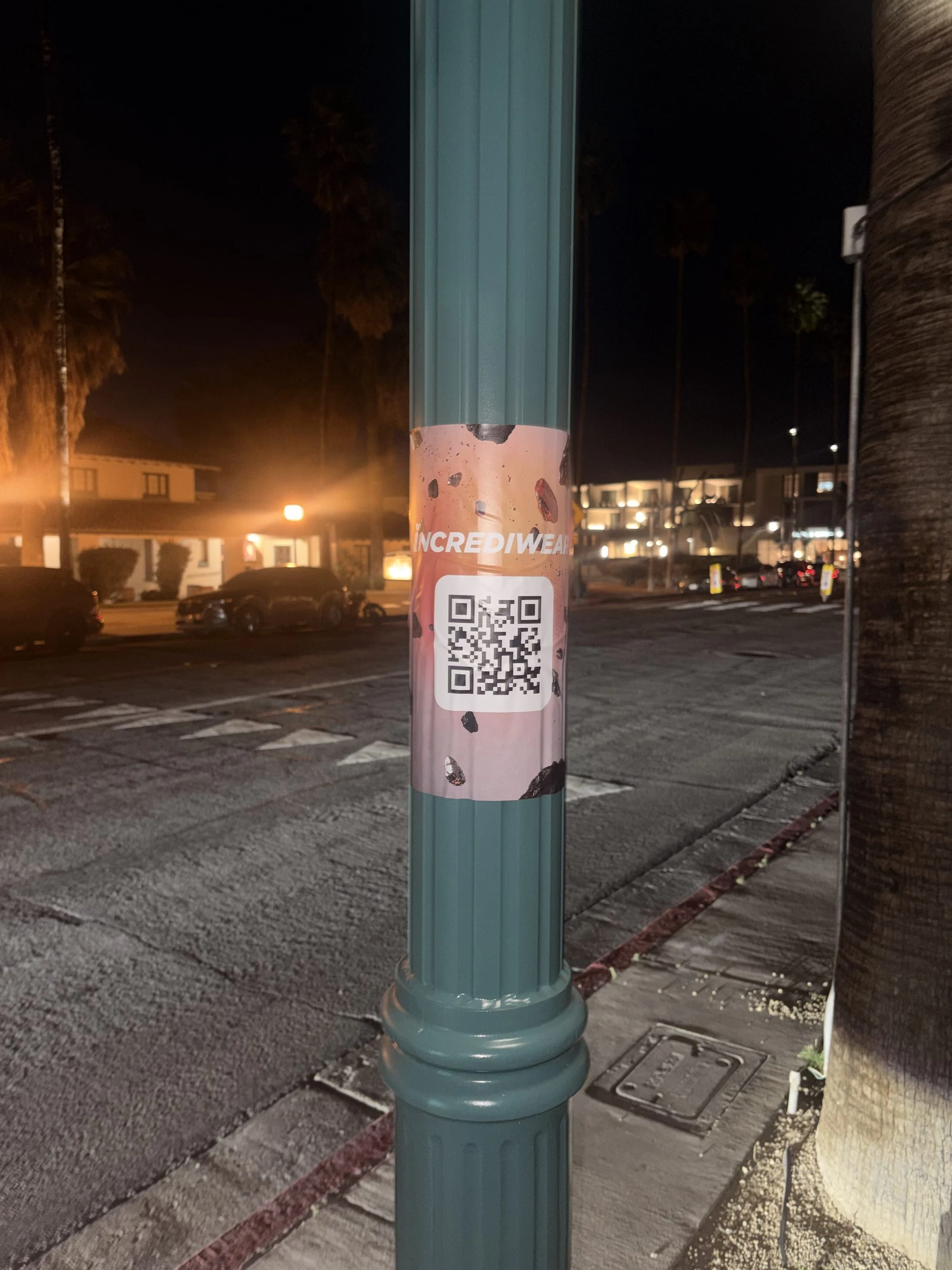Incrediwear pull-tab QR pole sticker in the Coachella Valley during the BNP Paribas Open, documented street install, by Beyond Street Media