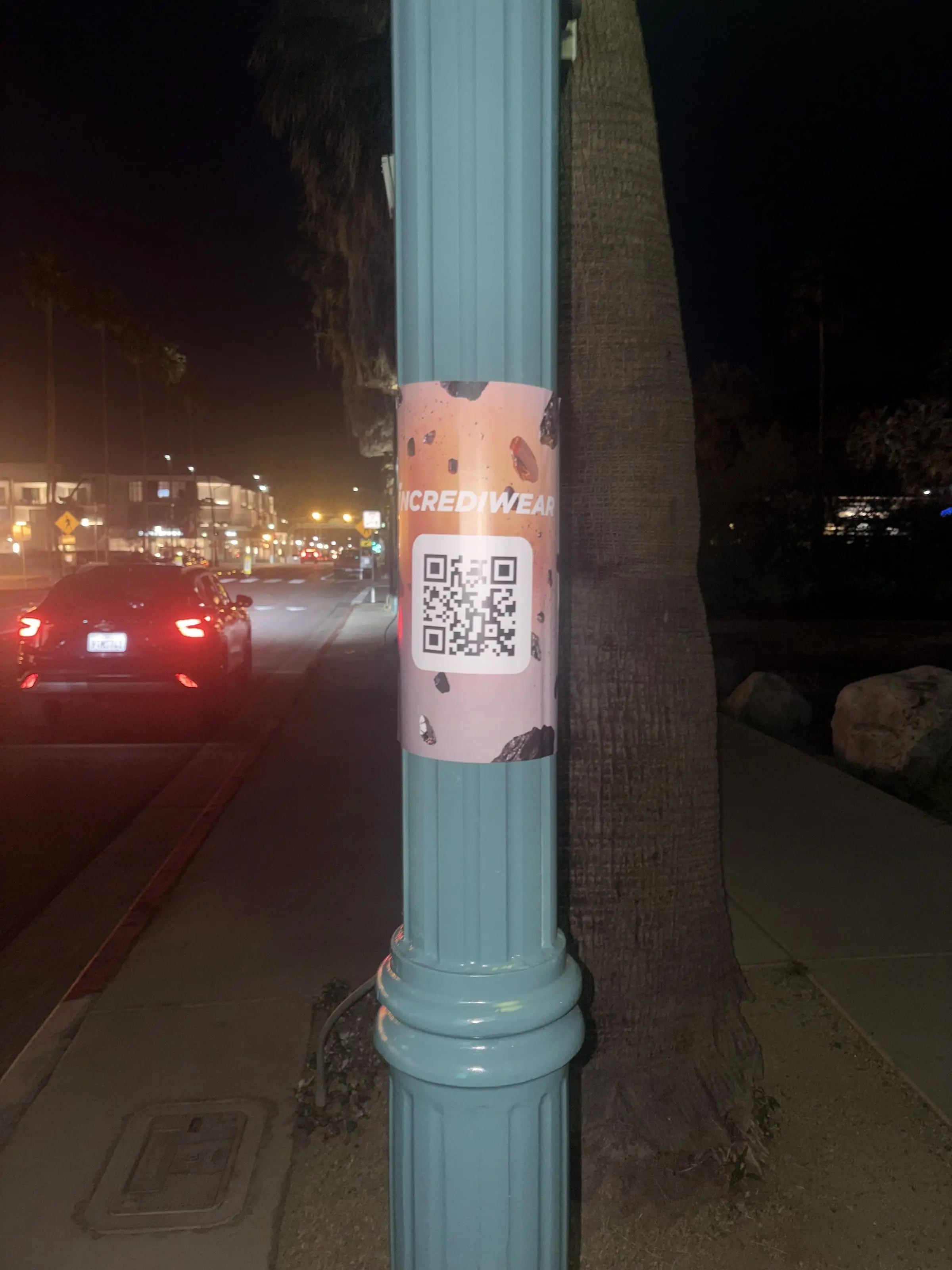 Incrediwear pull-tab QR pole sticker in the Coachella Valley during the BNP Paribas Open, documented street install, by Beyond Street Media