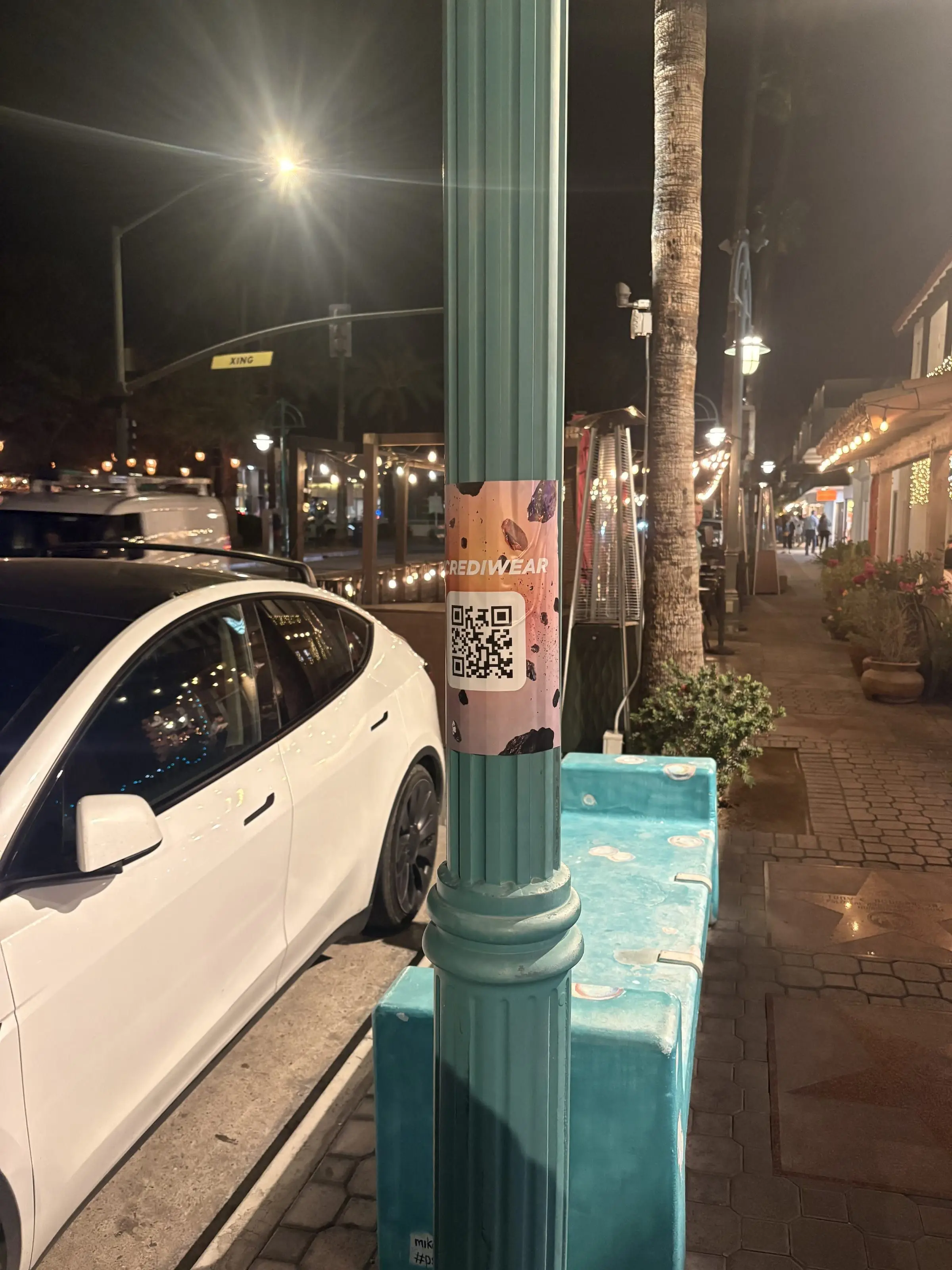 Incrediwear pull-tab QR pole sticker in the Coachella Valley during the BNP Paribas Open, documented street install, by Beyond Street Media
