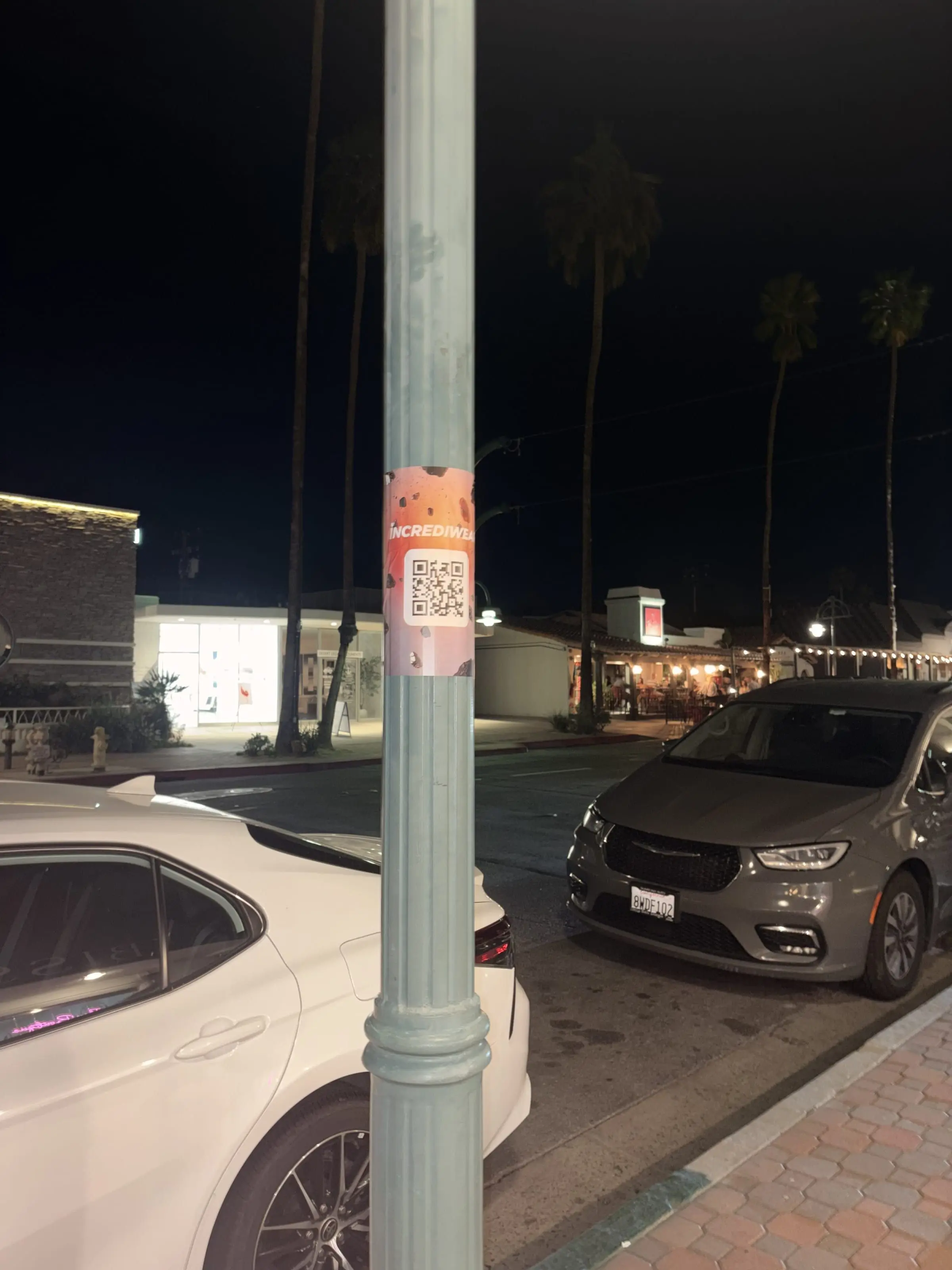 Incrediwear pull-tab QR pole sticker in the Coachella Valley during the BNP Paribas Open, documented street install, by Beyond Street Media