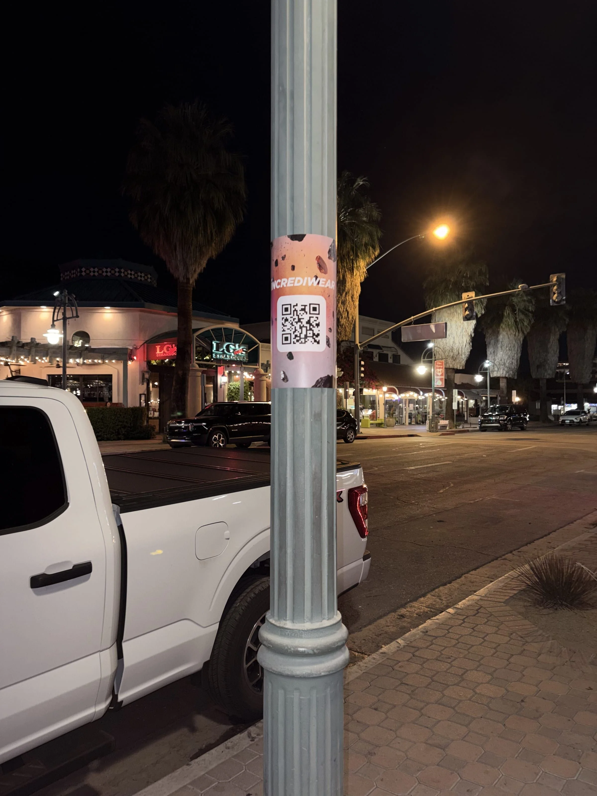 Incrediwear pull-tab QR pole sticker in the Coachella Valley during the BNP Paribas Open, documented street install, by Beyond Street Media