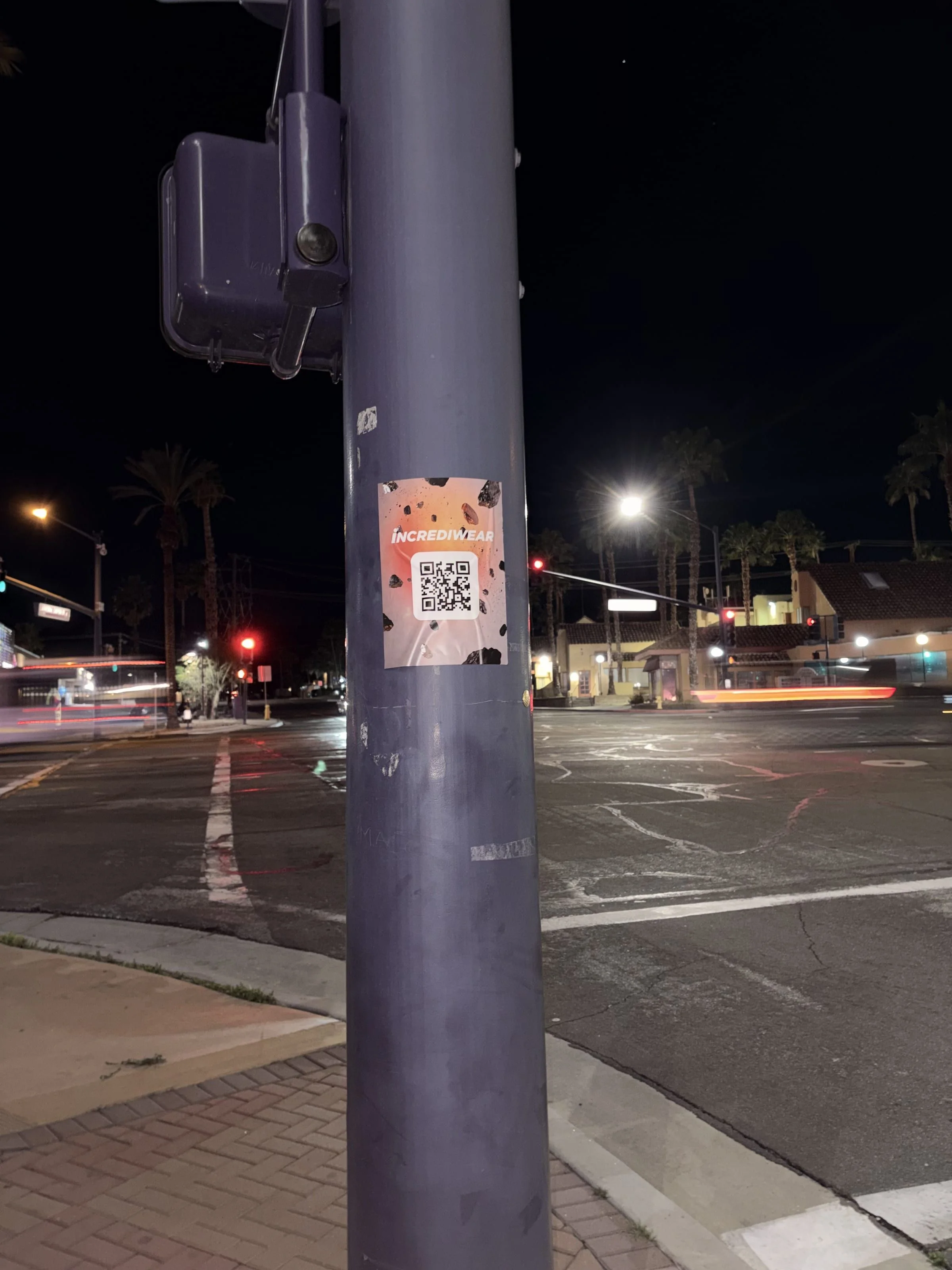 Incrediwear pull-tab QR pole sticker in the Coachella Valley during the BNP Paribas Open, documented street install, by Beyond Street Media