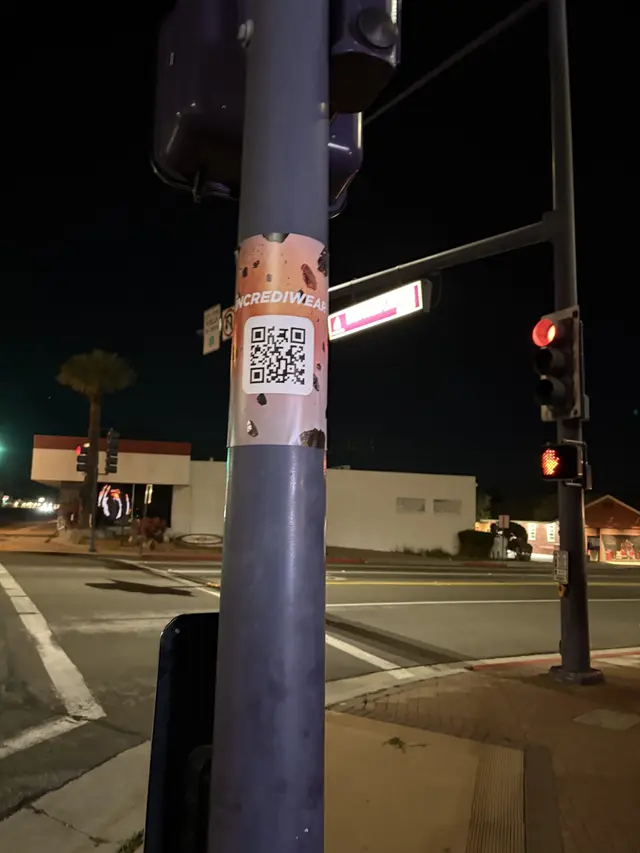 Incrediwear pull-tab QR pole sticker in the Coachella Valley during the BNP Paribas Open, documented street install, by Beyond Street Media (photo 10 of 38).