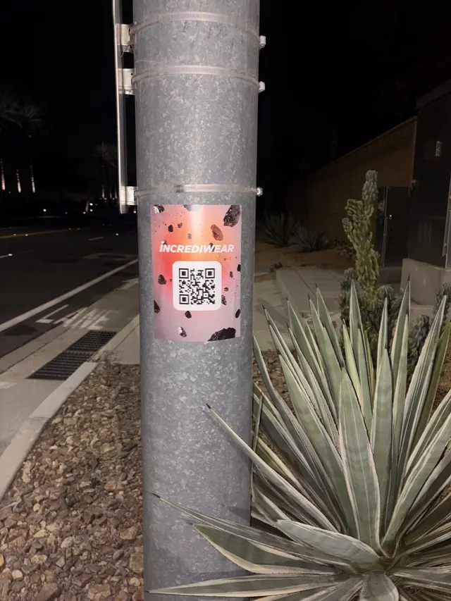 Incrediwear pull-tab QR pole sticker in the Coachella Valley during the BNP Paribas Open, documented street install, by Beyond Street Media (photo 11 of 38).