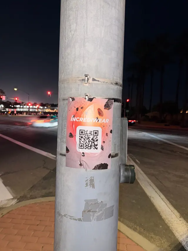 Incrediwear pull-tab QR pole sticker in the Coachella Valley during the BNP Paribas Open, documented street install, by Beyond Street Media (photo 13 of 38).