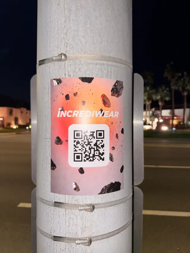 Incrediwear pull-tab QR pole sticker in the Coachella Valley during the BNP Paribas Open, documented street install, by Beyond Street Media (photo 14 of 38).