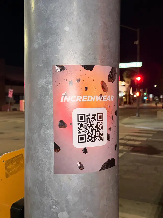 Incrediwear pull-tab QR pole sticker in the Coachella Valley during the BNP Paribas Open, documented street install, by Beyond Street Media (photo 15 of 38).