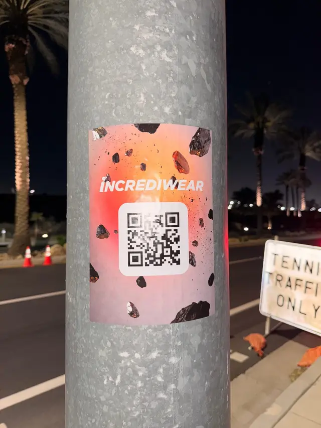 Incrediwear pull-tab QR pole sticker in the Coachella Valley during the BNP Paribas Open, documented street install, by Beyond Street Media (photo 16 of 38).