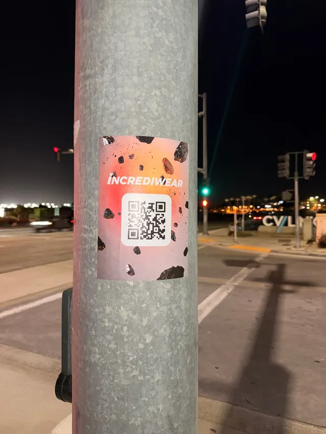 Incrediwear pull-tab QR pole sticker in the Coachella Valley during the BNP Paribas Open, documented street install, by Beyond Street Media (photo 17 of 38).