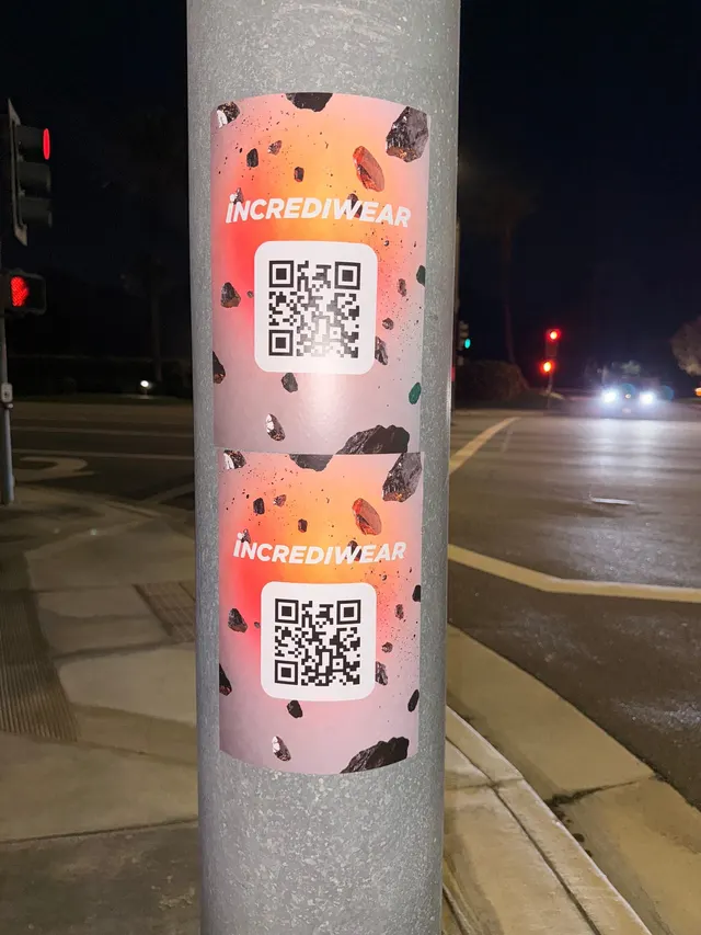 Incrediwear pull-tab QR pole sticker in the Coachella Valley during the BNP Paribas Open, documented street install, by Beyond Street Media (photo 18 of 38).