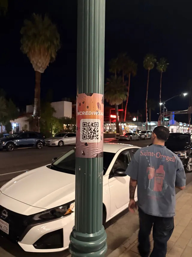Incrediwear pull-tab QR pole sticker in the Coachella Valley during the BNP Paribas Open, documented street install, by Beyond Street Media (photo 21 of 38).