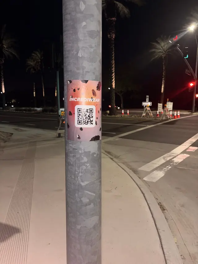 Incrediwear pull-tab QR pole sticker in the Coachella Valley during the BNP Paribas Open, documented street install, by Beyond Street Media (photo 22 of 38).