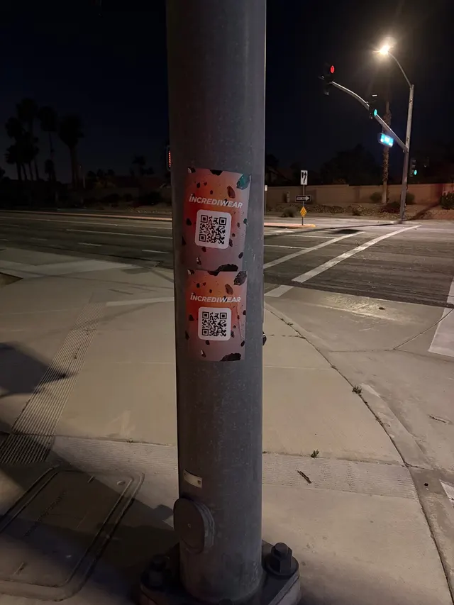 Incrediwear pull-tab QR pole sticker in the Coachella Valley during the BNP Paribas Open, documented street install, by Beyond Street Media (photo 23 of 38).