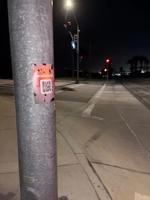 Incrediwear pull-tab QR pole sticker in the Coachella Valley during the BNP Paribas Open, documented street install, by Beyond Street Media (photo 24 of 38).