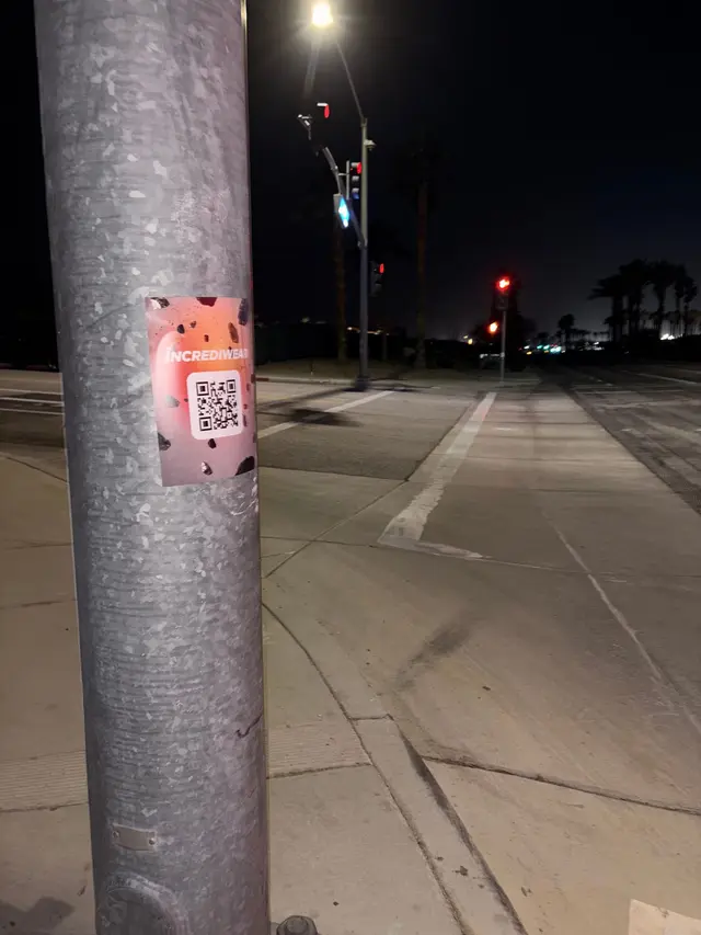 Incrediwear pull-tab QR pole sticker in the Coachella Valley during the BNP Paribas Open, documented street install, by Beyond Street Media (photo 24 of 38).