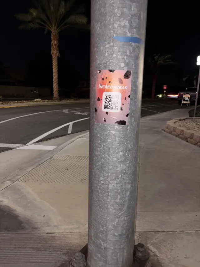 Incrediwear pull-tab QR pole sticker in the Coachella Valley during the BNP Paribas Open, documented street install, by Beyond Street Media (photo 25 of 38).