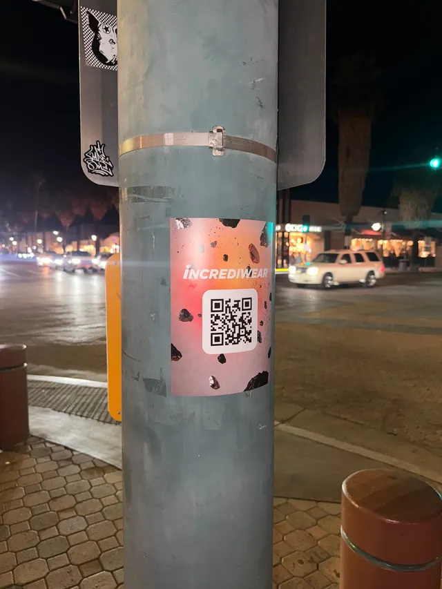 Incrediwear pull-tab QR pole sticker in the Coachella Valley during the BNP Paribas Open, documented street install, by Beyond Street Media (photo 28 of 38).