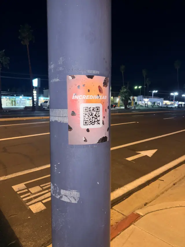 Incrediwear pull-tab QR pole sticker in the Coachella Valley during the BNP Paribas Open, documented street install, by Beyond Street Media (photo 31 of 38).