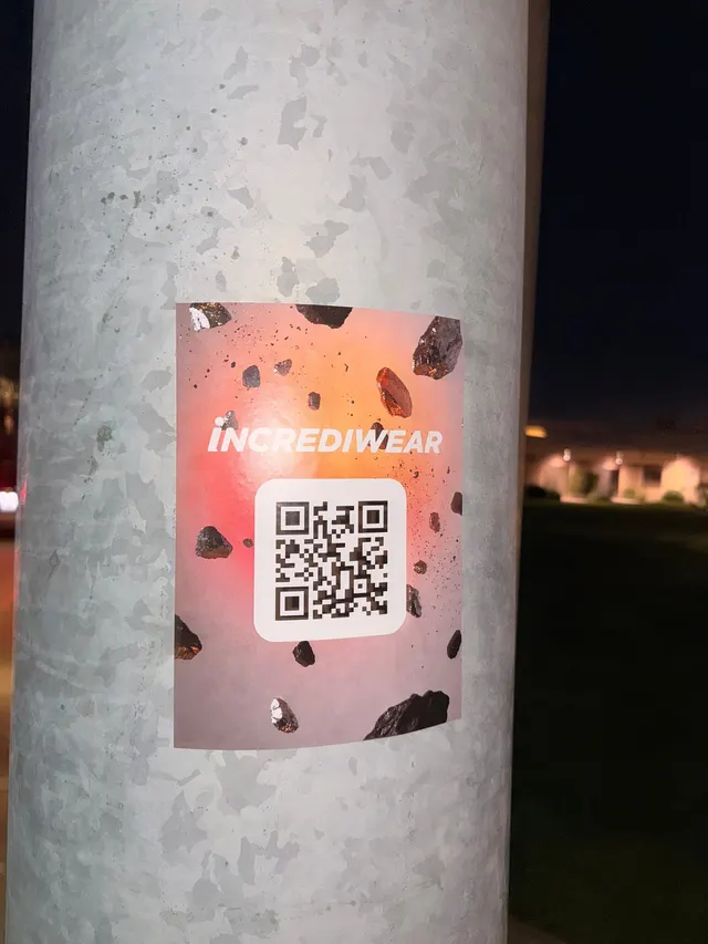 Incrediwear pull-tab QR pole sticker in the Coachella Valley during the BNP Paribas Open, documented street install, by Beyond Street Media (photo 32 of 38).