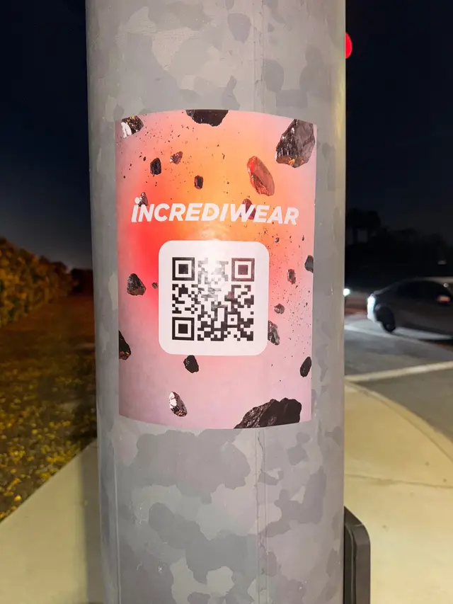 Incrediwear pull-tab QR pole sticker in the Coachella Valley during the BNP Paribas Open, documented street install, by Beyond Street Media (photo 33 of 38).