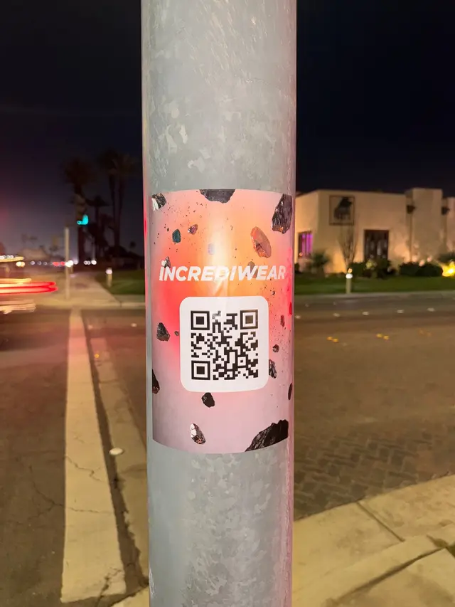 Incrediwear pull-tab QR pole sticker in the Coachella Valley during the BNP Paribas Open, documented street install, by Beyond Street Media (photo 34 of 38).