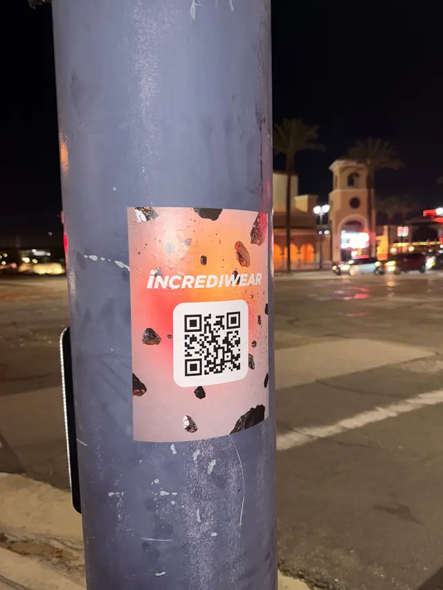 Incrediwear pull-tab QR pole sticker in the Coachella Valley during the BNP Paribas Open, documented street install, by Beyond Street Media (photo 37 of 38).