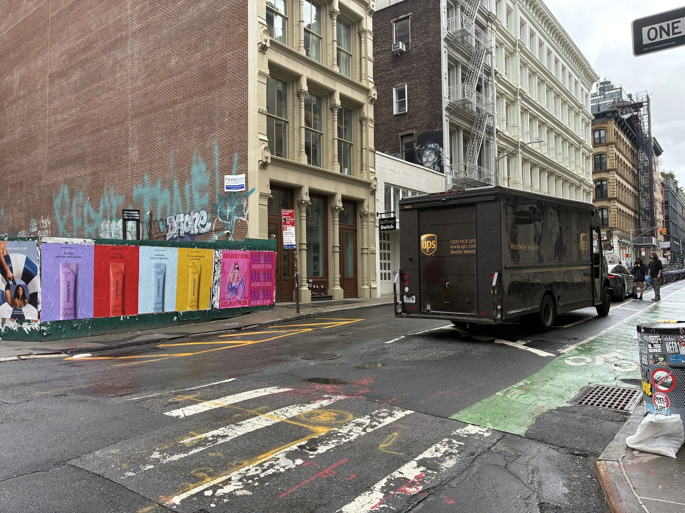 Momentm 48x72 poster run on a SoHo construction fence at a cobblestone corner, New York.
