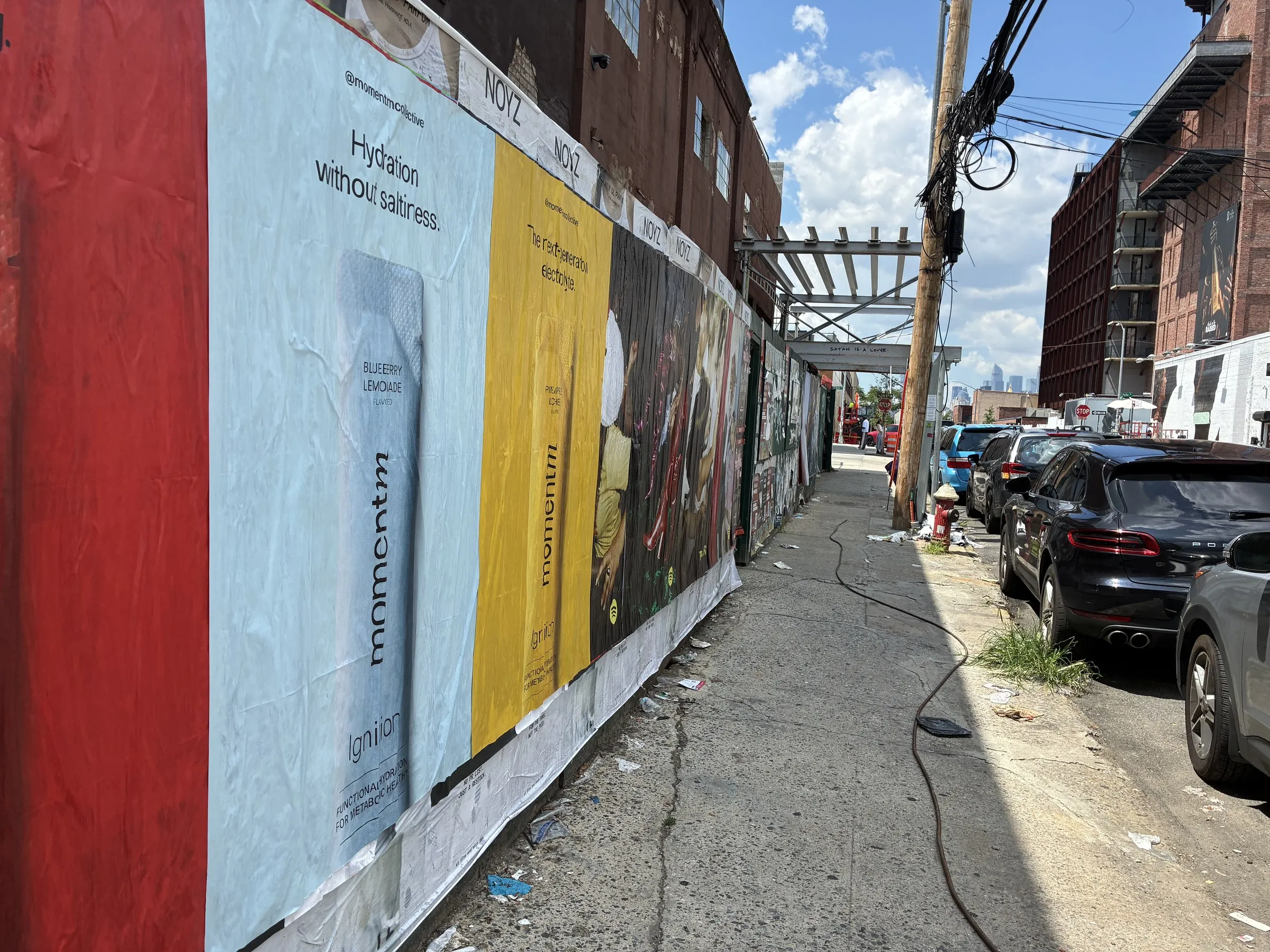 Frontal detail of a Momentm jumbo 48x72 poster set on hoarding, product cans at full scale.