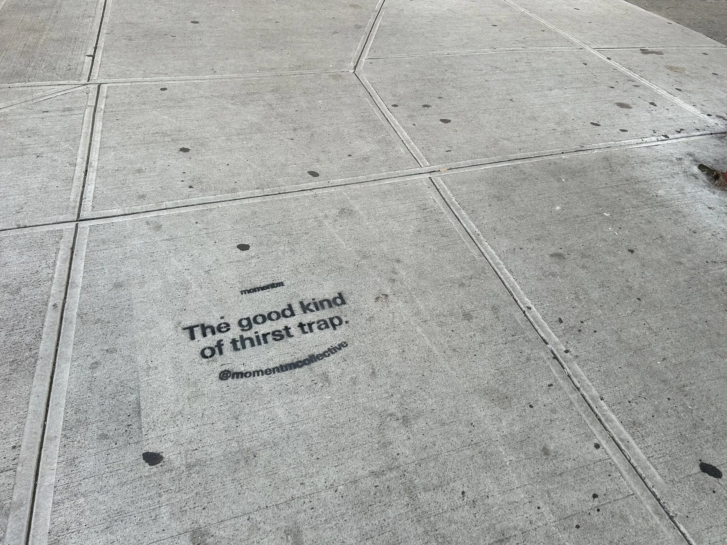Frontal Momentm sidewalk stencil, one of three approved designs, on New York concrete.