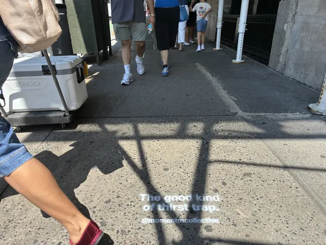 Foot traffic stepping past a Momentm sidewalk stencil in New York.