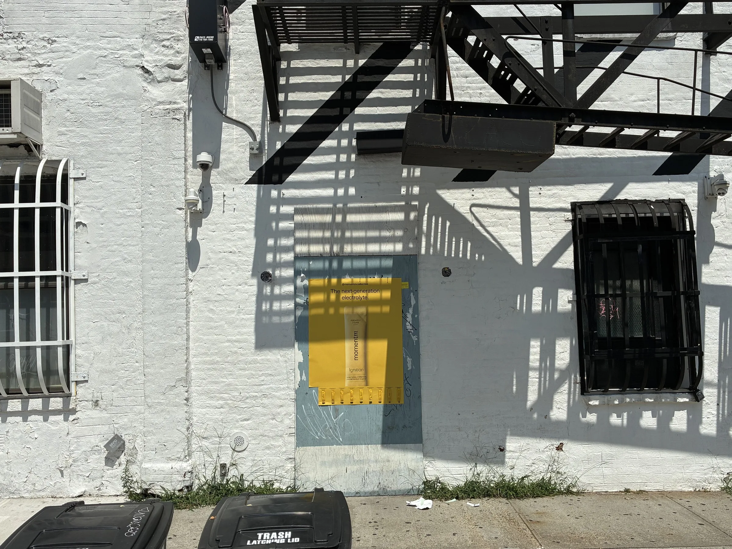 Wide wall view of a Momentm takeaway poster with its sample strip partly taken by passersby.
