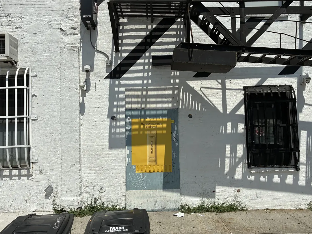 Wide wall view of a Momentm takeaway poster with its sample strip partly taken by passersby.