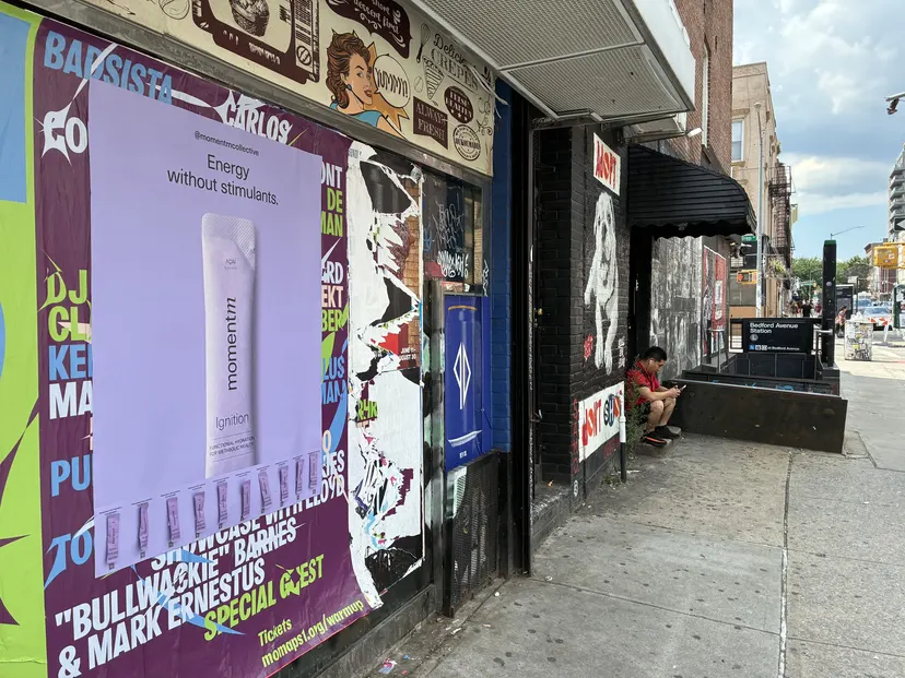 Momentm takeaway poster with product sample stick packs installed on a New York wall by Beyond Street Media.