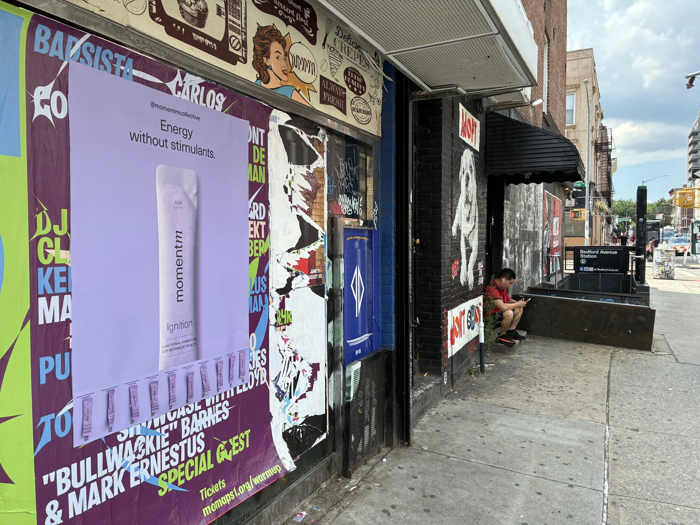 Momentm takeaway poster with product sample stick packs installed on a New York wall by Beyond Street Media.